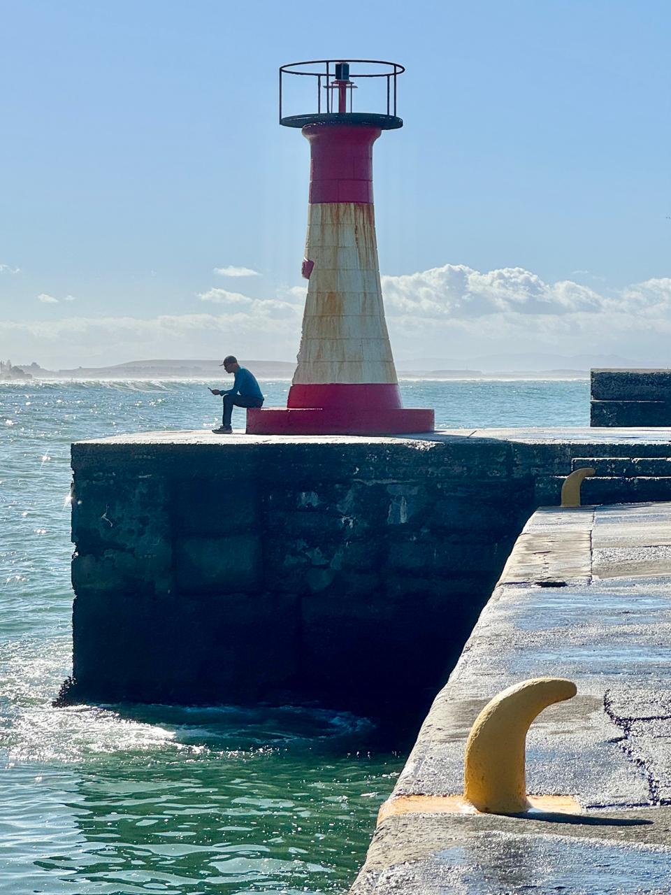 The red and white harbour lighthouse at Kalk Bay