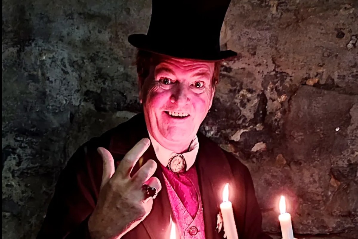 Ghost tour guide in a top hat holding a candelabra