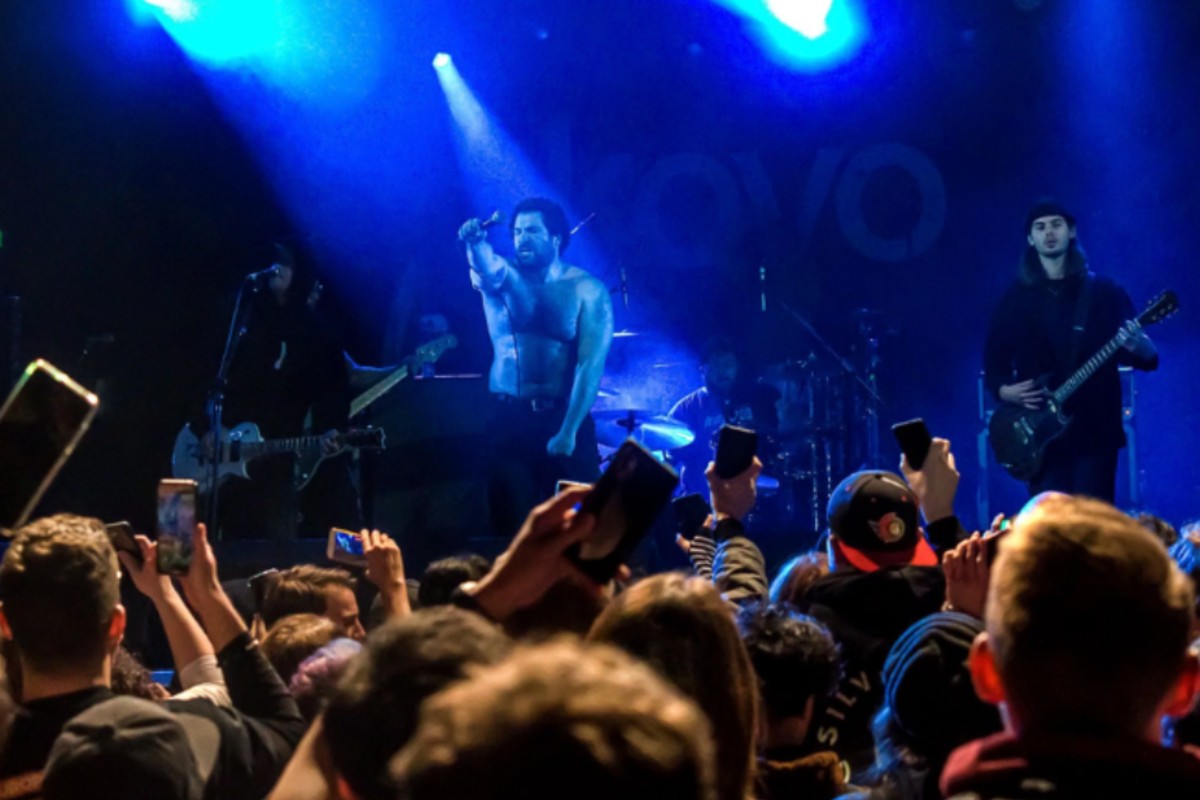 Band performing to a crowd under blue stage lights